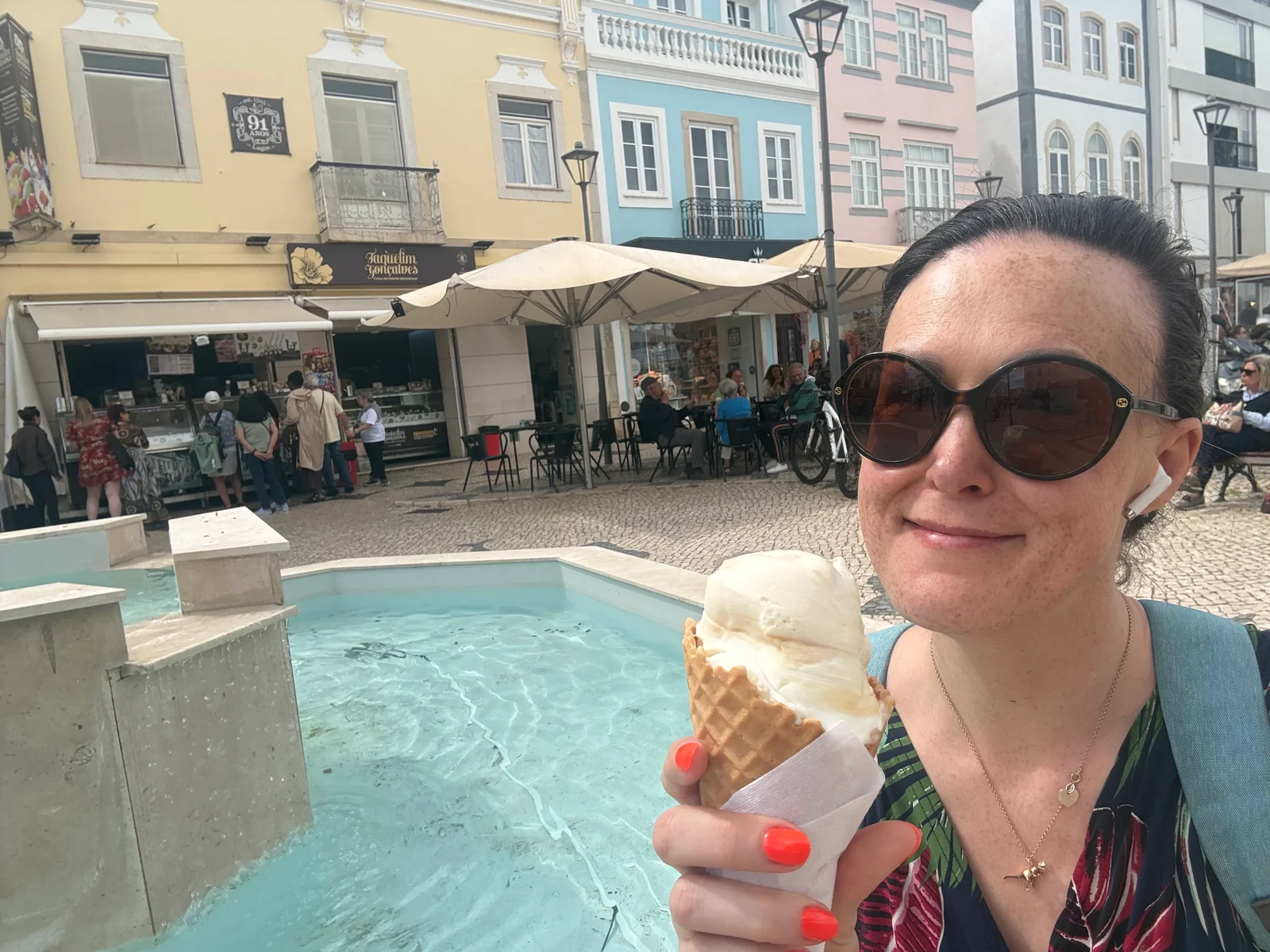 Clare enjoying an ice cream beside a fountain on her solo trip.