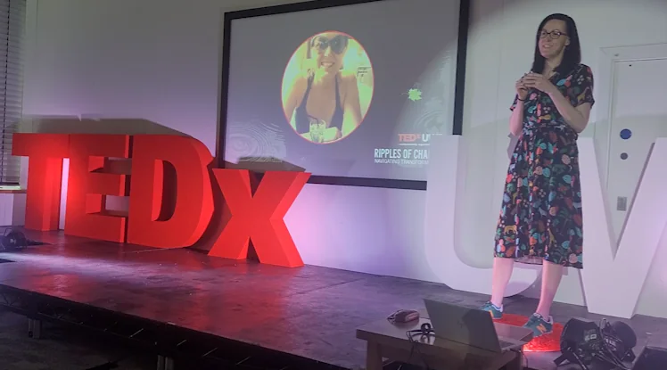 Clare E Kenny speaking on a TEDx stage